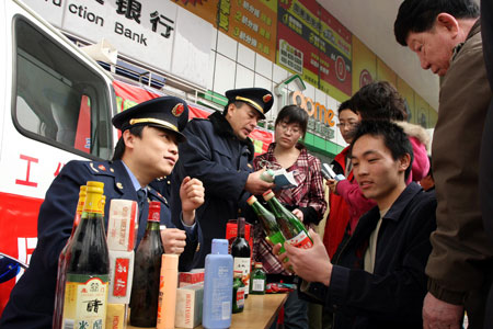 Officers (L) from local commerce administration answer people's questions during an event to mark the World Consumer Rights Day in Beijing March 15, 2009. Lots of such events were held across China on Sunday.[Zhang Xu/Xinhua]