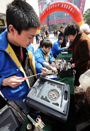 Technicians repair electric appliances for free during an event to mark the World Consumer Rights Day in Nanjing, east China's Jiangsu province, March 15, 2009. Lots of such events were held across China on Sunday.[Sun Can/Xinhua]