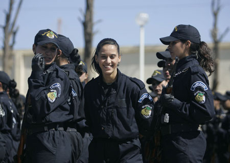 An instructress smiles as newly graduated female members of a police special unit marches during their graduation ceremony at the police academy in Ain Benian, Algiers, March 15, 2009. [Xinhua/Reuters]