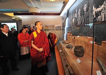 The 11th Panchen Lama Erdeni Gyaincain Norbu (front) looks at the exhibits during an exhibition titled 'Democratic Reform in the Tibet Autonomous Region' in Beijing, capital of China, March 15, 2009. [Fan Rujun/Xinhua] 