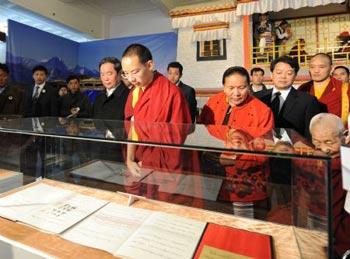 The 11th Panchen Lama Erdeni Gyaincain Norbu (front) looks at the exhibits during an exhibition titled 'Democratic Reform in the Tibet Autonomous Region' in Beijing, capital of China, March 15, 2009. [Fan Rujun/Xinhua]