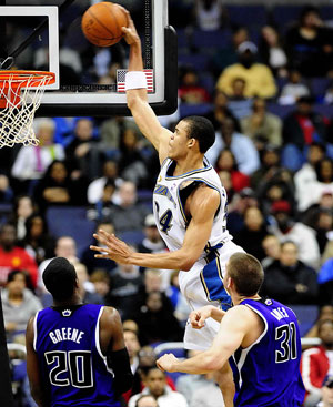 JaVale McGee (top) of Washington Wizards dunks during a NBA basketball match against Sacramento Kings in Washington, the United States, March 15, 2009. Wizards won the match 106-104.