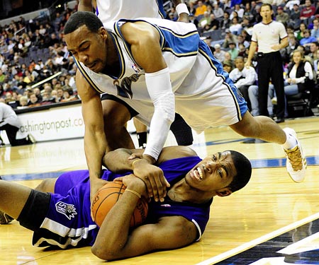 Javaris Critenton (top) of Washington Wizards vies for the ball with Jason Thompson of Sacramento Kings during the NBA basketball match in Washington, the United States, March 15, 2009. 