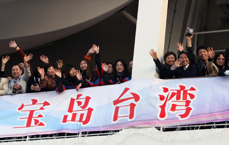Tourists wave hands to their relatives and friends before the passenger liner leaves for Taiwan, Shanghai, East China, March 14, 2009. It is the first tour group to the island by a passenger liner since the mainland and Taiwan started direct flights, postal and shipping services on December 15, 2008. [Xinhua]