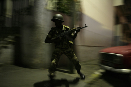 Madagascan pro-opposition armed forces successfully forced into a presidential palace on March 17 evening in the downtown of Antananarivo, Madagascar's capital, but President Marc Ravalomanana was not inside the building. A soldier runs while holding a weapon, after two tanks backed by troops forced their way into a presidential palace, in Antananarivo March 16, 2009. [Xinhua/Reuters]