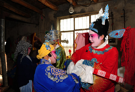 Performers prepare for a show at Halagui Village in Chaoyang County, northeast China's Liaoning Village, March 15, 2009. 