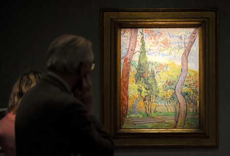 Visitors look at 'the Park of the Hospital Saint-Paul' of Van Gogh during the 22nd European Fine Art Fair TEFAF Maastricht 09, in Maastricht, Netherlands, March 15, 2009. [Wu Wei/Xinhua]