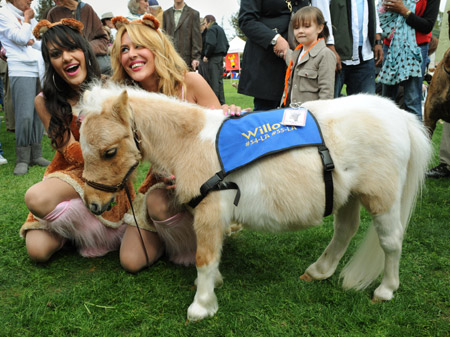 Visitors take pictures with an adult pet horse in an outdoor pet festival held in Los Angeles, March 15, 2009.[Xinhua/AFP]