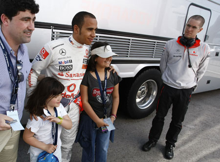 McLaren Formula One driver Lewis Hamilton (3rd L)of Britain poses with supporters in the paddock during a training session at the Jerez racetrack in southern Spain March 16, 2009.