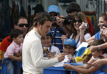 Renault Formula One driver Fernando Alonso of Spain takes time out to sign some autographs during a training session at the Jerez racetrack in southern Spain March 15, 2009. The F1 season will begin March 29 in Australia.