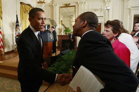  U.S. President Barack Obama (L) greets a participant in an event on helping small businesses recover from the economic crisis, in the East Room of the White House in Washington March 16, 2009. [Xinhua]