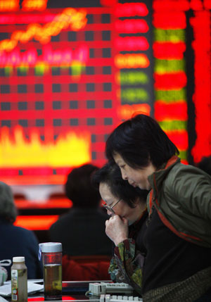 Chinese stock investors watch a stock indicator at a securities exchanging hall in east China's Shanghai Municipality, on March 17, 2009. China's benchmark Shanghai Composite Index on the Shanghai Stock Exchange closed at 2,218.33 points Tuesday, up 65.04 points, or 3.02 percent, from the previous close.[Xinhua]