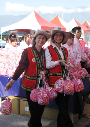 Chinese mainland tourists hold presents received as they arrive in Hualien of southeast China's Taiwan March 17, 2009. The first group of Chinese mainland tourists to Taiwan by a passenger liner, which was the first since the mainland and Taiwan started direct air, postal and shipping services on Dec. 15, 2008, visited Hualien March 17.[Wang Yan/Xinhu]