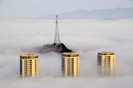  Photo taken on March 17, 2009 shows buildings enveloped in the heavy fog in Taizhou, east China's Zhejiang Province.[Wang Tianrong/Xinhua]