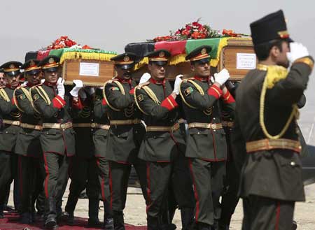 Afghan honour guards carry the coffins of Afghanistan's first president, Mohammad Daud Khan, and his brother Naeem Khan, during a ceremony to rebury his remains in Kabul March 17, 2009. [Xinhua/Reuters]