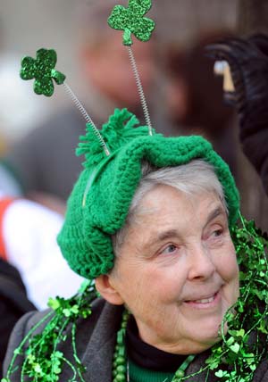 A spectator watches the St. Patrick's Day Parade along the Fifth Avenue in New York, the United States, March 17, 2009. Hundreds of thousands of people on Tuesday gathered along Fifth Avenue, a major thoroughfare in the center of the borough of Manhattan in New York City, to watch St. Patrick's Day Parade.[Shen Hong/Xinhua]