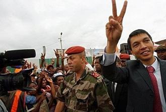 Madagascar opposition leader Andry Rajoelina gives the V for victory sign as he parades through the streets of Antananarivo. [Alexander Joe/AFP] 