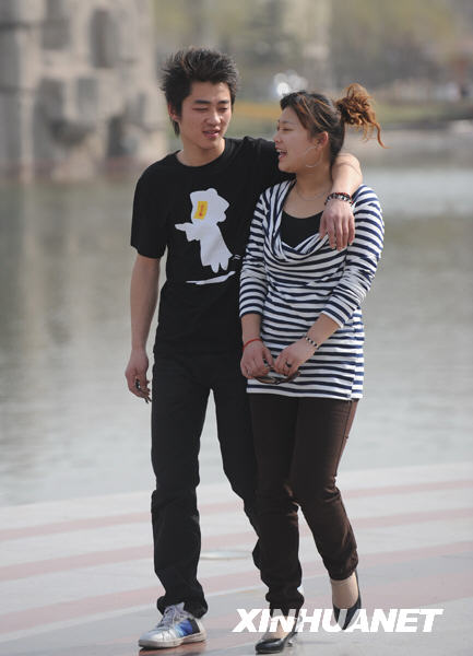 Two young people in T-shirts visit Century Park in Shijiazhuang City on March 17. 