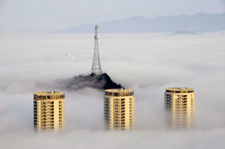 Photo taken on March 17, 2009 shows buildings enveloped in the heavy fog in Taizhou, east China's Zhejiang Province. [Wang Tianrong/Xinhua] 