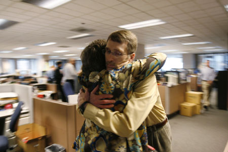 Seattle Post-Intelligencer photo editor John Dickson hugs AME Chris Beringer after Roger Oglesby, publisher and editor, announced to the staff that Tuesday's paper would be the final print edition of the Seattle Post-Intelligencer during a brief meeting in Seattle March 16, 2009.[Xinhua]