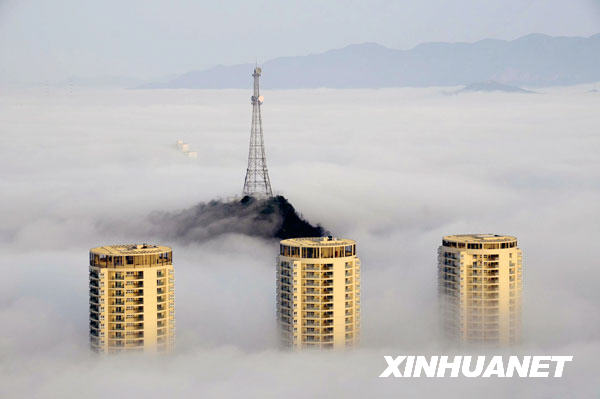 Buildings are enveloped by thick fog in Taizhou City, East China&apos;s Zhejiang Province, March 17, 2009. 
