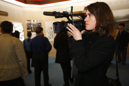 A foreign correspondent works at the '50th Anniversary of Democratic Reforms in Tibet' Exhibition in Beijing, capital of China, March 18, 2009. A number of foreign journalists, organized by the Information Department of China's Foreign Ministry, visited the exhibition on Wednesday. [Li Mingfang/Xinhua]