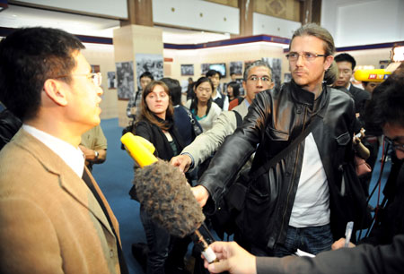 Zhang Yun (L), a researcher of the Tibetology Research Center of China, answers questions from foreign correspondents at the '50th Anniversary of Democratic Reforms in Tibet' Exhibition in Beijing, capital of China, March 18, 2009. A number of foreign journalists, organized by the Information Department of China's Foreign Ministry, visited the exhibition on Wednesday.[Xie Huanchi/Xinhua]