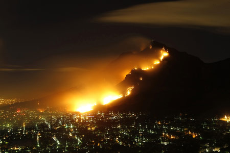 A massive bush fire sweeps across Cape Town's Table Mountain, March 18, 2009, causing hundreds of people to be evacuated as the flames threatened buildings. Strong south easterly winds, coupled with hot dry weather, have fanned hundreds of bush fires across the province in recent weeks. [Xinhua/Reuters]