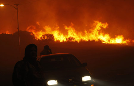 Police evacuate residents as a massive bush fire sweeps across Cape Town's Table Mountain March 18, 2009. [Xinhua/Reuters]