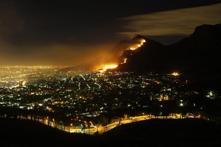 A massive bush fire sweeps across Cape Town's Table Mountain March 18, 2009, causing hundreds of people to be evacuated as the flames threatened buildings. Strong south easterly winds, coupled with hot dry weather, have fanned hundreds of bush fires across the province in recent weeks. [Xinhua/Reuters]