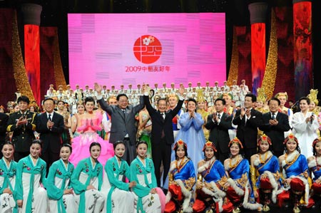 Chinese Premier Wen Jiabao (6th R, 2nd Line) and his counterpart of the Democratic People's Republic of Korea (DPRK) Kim Yong Il (4th L, 2nd Line) wave as they pose for a group photo with performers after the performance for the launch of the China-DPRK Friendship Year in Beijing, capital of China, March 18, 2009. [Li Tao/Xinhua]