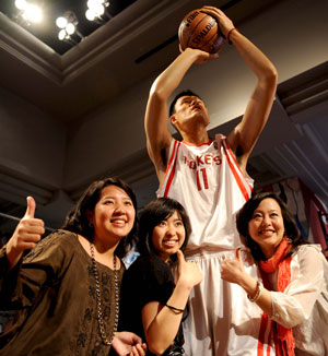 Three ladies have photos taken with the lifesize wax figure of Yao Ming, one of the most popular and beloved basketball players in both China and the United States, at the Madame Tussauds in New York of the United States, March 18, 2009. 