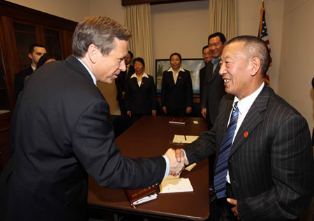 Shingtsa Tenzinchodrak (R Front), a living Buddha of the Kagyu sect of the Tibetan Buddhism and vice chairman of the Standing Committee of the People's Congress of Tibet Autonomous Region of China, shakes hands with Mark Kirk (L Front), chairman of the U.S.-China Working Group in the House, in Washington, the United States, March 17, 2009. [Xinhua]