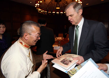 Shingtsa Tenzinchodrak (L), a living Buddha of the Kagyu sect of the Tibetan Buddhism and vice chairman of the Standing Committee of the People's Congress of Tibet Autonomous Region of China, presents books about Tibet to Richard Bush, a researcher of the Brookings Institution in Washington, the United States, March 17, 2009.