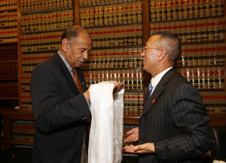 Shingtsa Tenzinchodrak (R), a living Buddha of the Kagyu sect of the Tibetan Buddhism and vice chairman of the Standing Committee of the People's Congress of Tibet Autonomous Region of China, presents a Hada to John Conyers, U.S. House Judiciary Committee chairman, in Washington, the United States, March 17, 2009. [Xinhua]