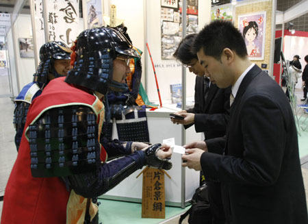 Promotional staff at Japan's traditional warrior's outfits exchange name cards with visitors at Tokyo International Anime Fair 2009 in Tokyo March 18, 2009.[Xinhua/Reuters]