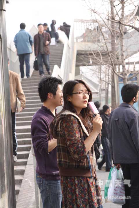 Photo taken in Haidian District of Beijing shows a girl is eating an ice cream March 18, 2009.