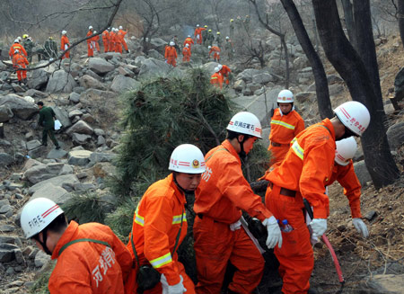 Firemen set up a fireproof zone for a forest fire at Junying Village of Zanhuang County, north China's Hebei Province, March 18, 2009. The fire starting on March 16 has engulfed 26.7 hectares of forest by March 18. [Yang Shiyao/Xinhua]