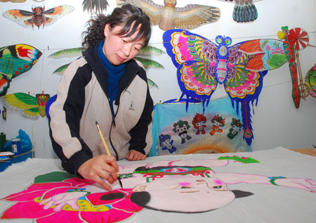 A handicraftswoman draws vivid patterns of folklore figures of traditional Chinese New Year paintings on the surface of kites, at Yangjiabu Town, Weifang City, east China's Shandong Province, March 18, 2009. With reputation as one of the top three production bases for wood carving New Year paintings in China, Yangjiabu Town boasts of an annual capacity of making over 1.1 million folklore kites, which sells to more than 20 countries and regions. (Xinhua/Wang Lijun)