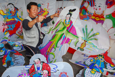 A handicraftsman elaborates on a kite with vivid patterns of folklore figures of traditional Chinese New Year paintings, at Yangjiabu Town, Weifang City, east China's Shandong Province, March 18, 2009. With reputation as one of the top three production bases for wood carving New Year paintings in China, Yangjiabu Town boasts of an annual capacity of making over 1.1 million folklore kites, which sells to more than 20 countries and regions. (Xinhua/Wang Lijun)