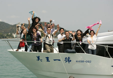 Tourists from the Chinese mainland visit the Sun-Moon Lake in southeast China's Taiwan Province March 18, 2009. Groups of over 10,000 mainland tourists organized by Gangzhong Lu International Travel Agency are in their trips to Taipei, Keelung, Hualien and the Sun-Moon Lake in succession. [Xinhua]