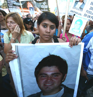 A woman attends an anti-violent crimes rally with the photo of her relative in Buenos Aires, March 18, 2009. Some 8,000 citizens gathered at downtown Buenos Aires Wednesday to call for the government to take actions in striking the violent crimes and ensure the public security.[Martin Zabala/Xinhua]