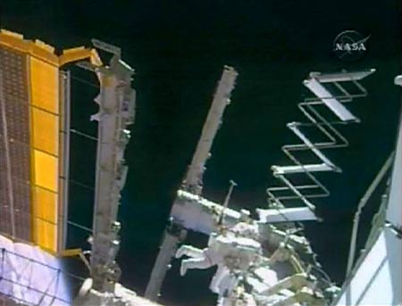 Astronaut Steve Swanson works to install the International Space Station's new truss assembly and solar array in this March 19, 2009 NASA TV video grab. [Xinhua/Reuters]