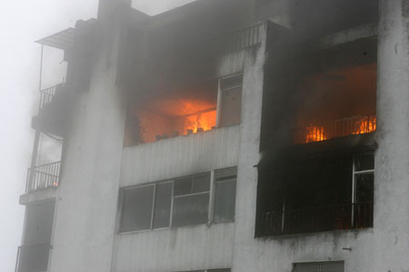 Fire engulfs a building after a plane crashed on its roof in Quito March 19, 2009. At least five people were killed when the Ecuadorean military plane crashed into two buildings on Thursday in the fog-bound capital city Quito, authorities said. [Xinhua/Reuters]