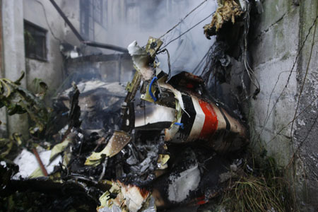 The wreckage of a plane is seen in the backyard of a building after a plane crashed in Quito March 19, 2009.[Xinhua/Reuters]