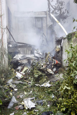 The wreckage of a plane is seen in the backyard of a building in Quito March 19, 2009.[Xinhua/Reuters]