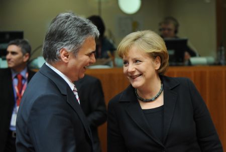 German Chancellor Angela Merkel (R) talks with Austrian Federal Chancellor Werner Faymann during the first day meeting of EU spring summit in Brussels, capital of Belgium, March 19, 2009. [Wu Wei/Xinhua]