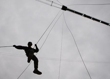 A member of the U.S. Marine Corps Fleet Antiterrorism Security Team Pacific, comprising of 46 marines from a military base in Norfolk, Virginia and deployed currently to Japan's Yokosuka, participates in a mountain warfare drill in Pohang, about 370 km (230 miles) southeast of Seoul, Mar. 20, 2009. [Xinhua/Reuters] 