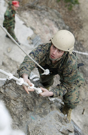 A member of the U.S. Marine Corps Fleet Antiterrorism Security Team Pacific, comprising of 46 marines from a military base in Norfolk, Virginia and deployed currently to Japan's Yokosuka, conducts a mountain warfare drill in Pohang, about 370 km (230 miles) southeast of Seoul, Mar. 20, 2009. [Xinhua/Reuters]