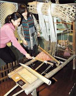 Visitors have a close look at the ancient loom at the Shanghai Museum of Textile and Costume in Donghua University. [Shanghai Daily] 